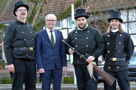 zu sehen sind der neue Schornsteinfeger mit seinem Vorgänger sowie Landrat Müller und dem Vorsitzenden der Schornsteinfeger-Innung